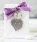 <p>Набор для бонбоньерок из белого картона украшенная фиолетовым бантиком и металлическими аксессуарами в форме сердца.</p>